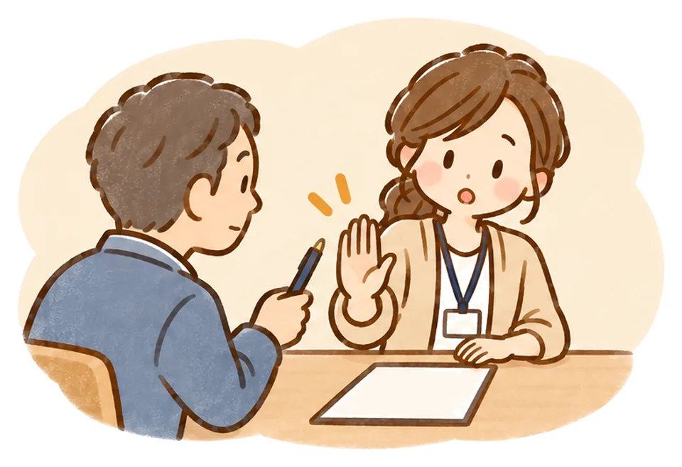 契約書の前で家族がペンを差し出し、ケアマネが手のひらでそっと止めている
