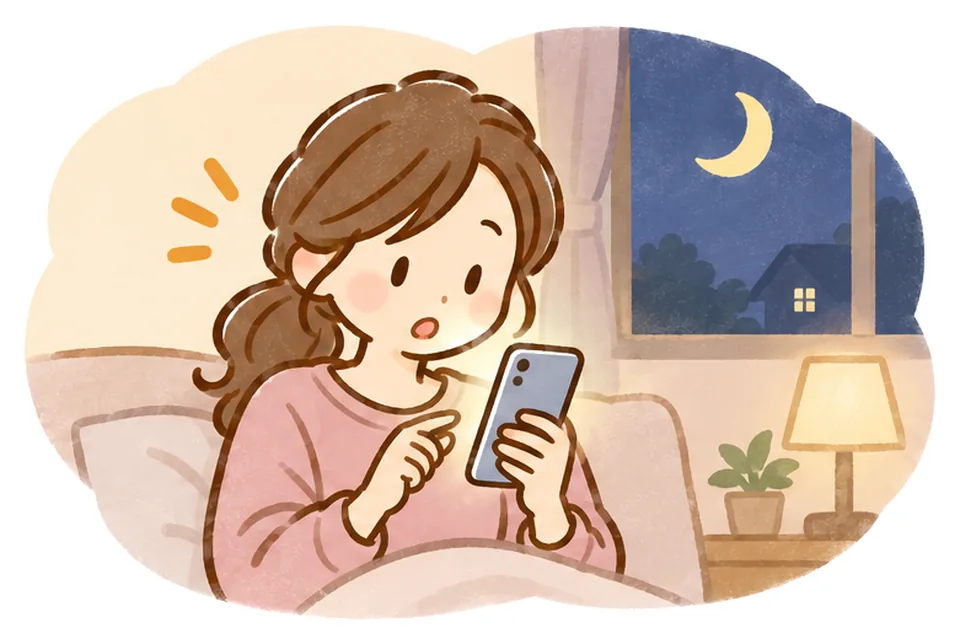 夜、自宅で部屋着のケアマネが光るスマートフォンを見てはっとしている