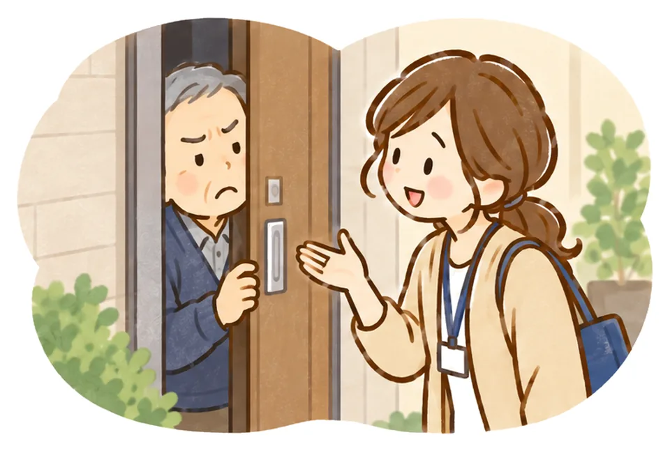 少しだけ開いたドアから顔をのぞかせるおじいさんに、ケアマネがやさしく話しかけている