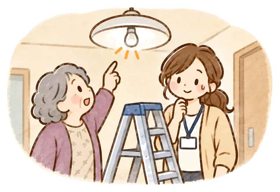 切れた電球を指すおばあさんと、脚立を見て困った笑顔のケアマネ